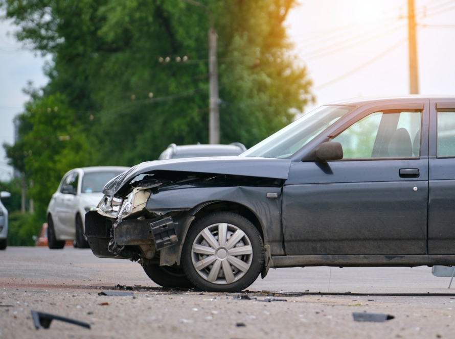 Damaged in car accident vehicle on city street crash site